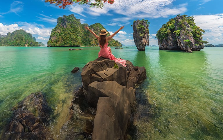 Oceania Cruises summer and winter sale featuring scenic tropical limestone cliffs and turquoise waters, advertising up to 40% off with free excursions and gourmet dining.