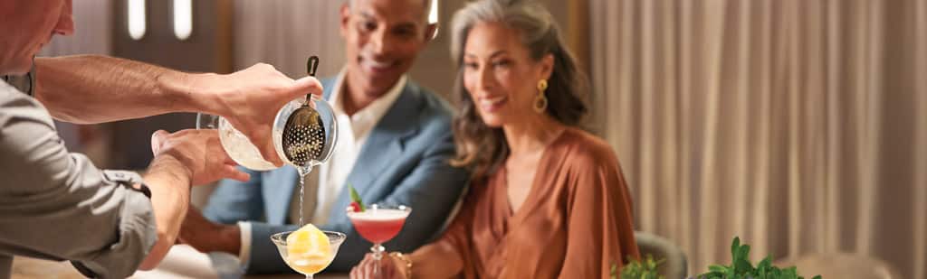 Couple enjoying drinks at the Founders Bar onboard Oceania Cruises