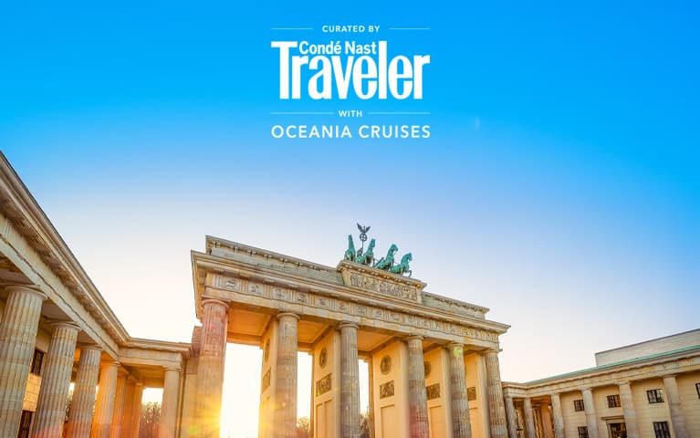 Traditional red-sailed junk boat sailing across Victoria Harbour with the Hong Kong skyline and a golden sunset in the background.