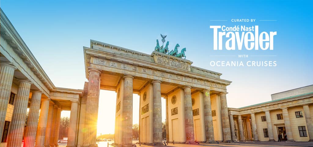 Traditional red-sailed junk boat sailing across Victoria Harbour with the Hong Kong skyline and a golden sunset in the background.